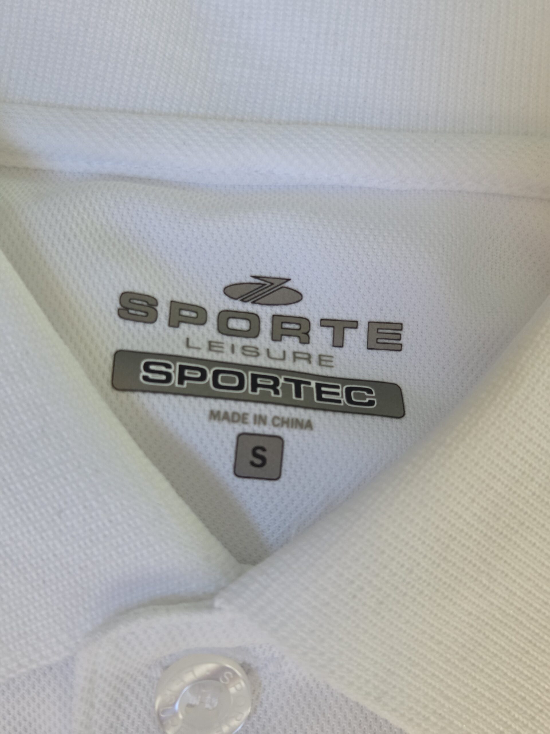 Close-up of a white polo shirt collar with SPORTEC brand label at Park Regis, Sydney.