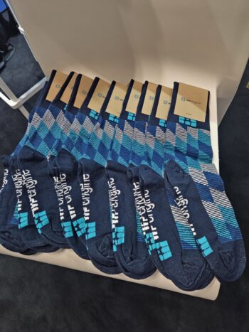 Eight pairs of blue patterned socks—buyers, ask about minimum order quantities—on a white chair.