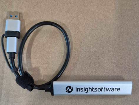A silver USB device—ideal as client gifts for financial planners—on a plain brown surface.