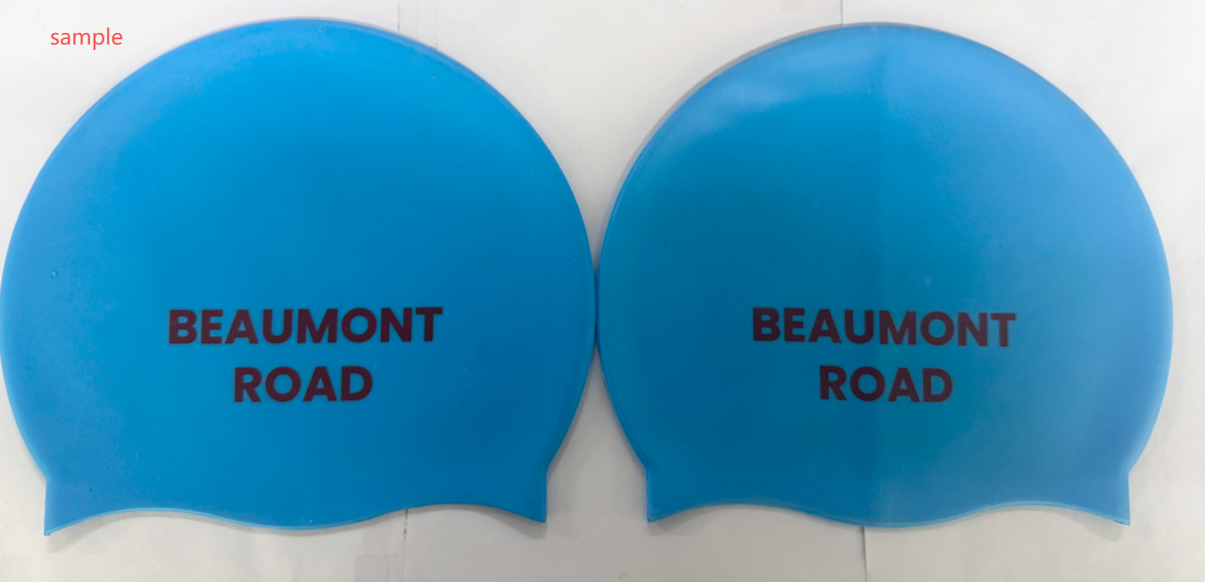 Two blue swim caps with BEAUMONT ROAD printed on them in black text.